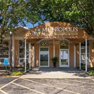 A commercial building entrance surrounded by trees.