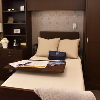 Cozy bedroom setup with a neatly arranged bed, pillows, and a wooden tray.