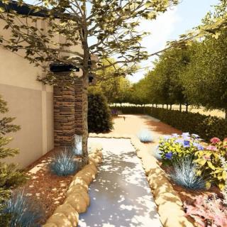 A beautifully landscaped garden pathway lined with trees and flowers beside a house.