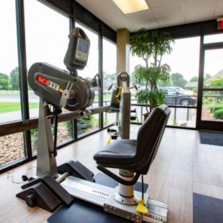 A fitness center featuring a stationary exercise machine near large windows.