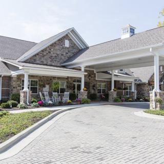 A residential building with a stone facade and a covered entrance.