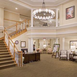 A spacious and elegantly decorated lobby with a staircase and chandelier.