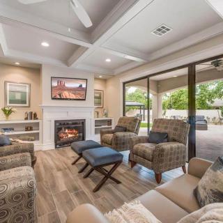 A modern living room with a cozy fireplace, ample seating, and natural light streaming through sliding glass doors.