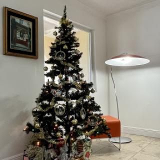 A beautifully decorated Christmas tree in a modern living room setting.