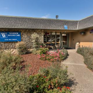 The exterior of a modern building featuring well-maintained landscaping and clear signage.