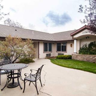 A cozy residential house with a spacious patio and outdoor seating.