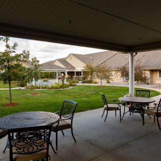 A peaceful patio with outdoor seating overlooking a well-maintained garden.