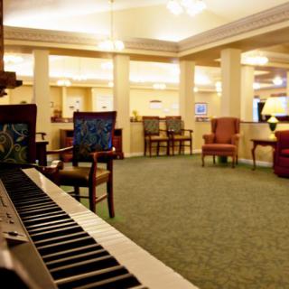 A cozy lounge area featuring a piano and comfortable seating arrangements.