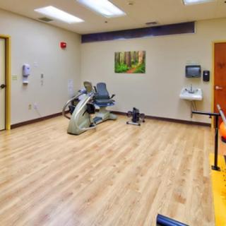 A physical therapy room equipped with exercise machines and a clean, spacious environment.