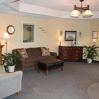 A cozy living room with a brown couch, coffee table, and various decor items.