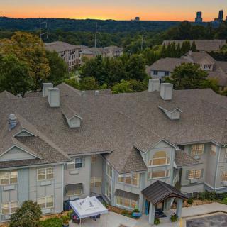 A suburban residential building at sunset with a view of the surrounding landscape.