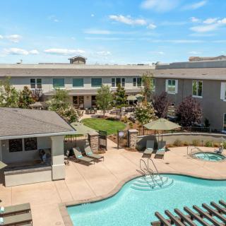 A modern apartment complex with a swimming pool and outdoor amenities.