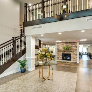 A modern living area featuring a staircase, open space, and a fireplace with stylish decor.