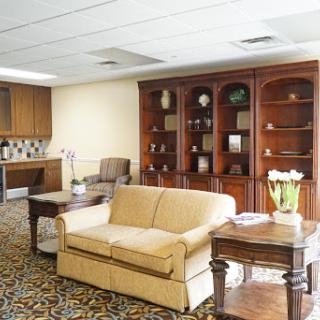 A cozy living room featuring a beige sofa, wooden bookshelf, and a decorative centerpiece on the table.