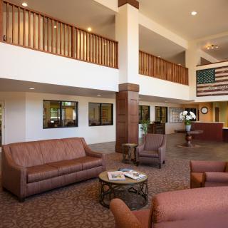 A spacious hotel lobby with comfortable seating and a reception desk.