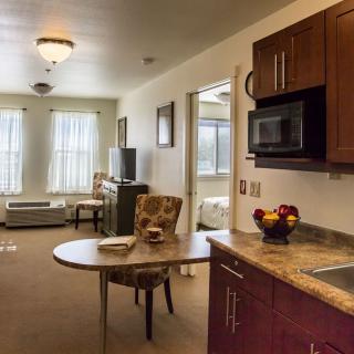 A cozy living area featuring a kitchenette with modern appliances and a comfortable seating arrangement.
