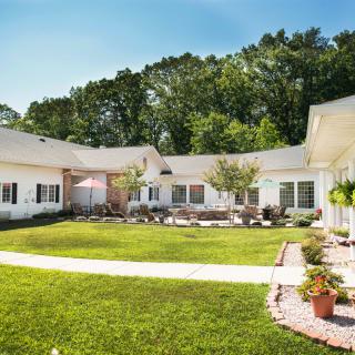 A peaceful courtyard with a well-maintained lawn surrounded by buildings and trees.