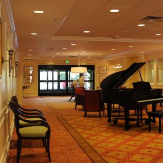 A hotel lobby with a grand piano and comfortable seating.