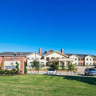 A large building with a manicured lawn and clear blue sky.