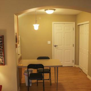 A small dining area with a table and two chairs under warm lighting.