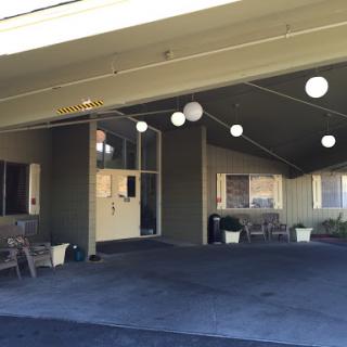 A view of the entrance to a building with outdoor seating and decorative lights.