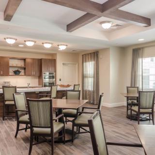 A modern dining room with wooden beams and an open kitchen area.