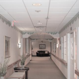 A long, decorated hallway with furniture and lighting fixtures along the walls.