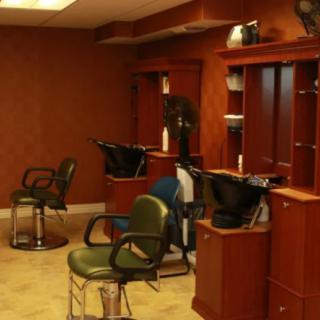 An interior view of a hair salon featuring several barber chairs and mirrors.
