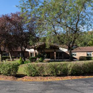 A cozy building surrounded by trees and well-maintained landscaping.