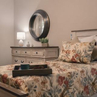 A cozy bedroom with floral bedding and elegant decor.