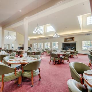 A spacious and elegantly decorated dining area with neatly arranged tables and chairs.