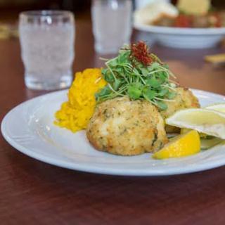 Delicious crab cakes served with a fresh garnish and lemon slices.