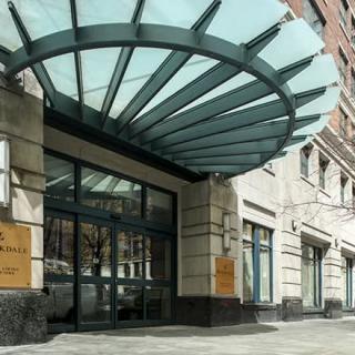 The entrance of a modern building featuring a distinctive glass canopy.