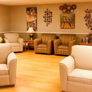 A cozy living room with comfortable chairs and decorative artwork on the walls.