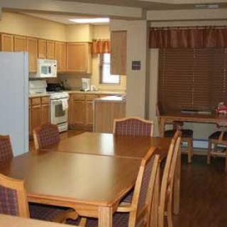 A cozy dining area adjacent to a kitchen with wooden furniture and cabinetry.