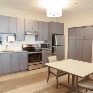 Modern kitchen with gray cabinets and dining area.