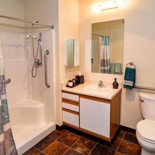 A modern bathroom featuring a shower, sink, and toilet.