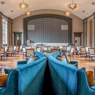 An elegant and luxurious interior space with plush blue sofas and neatly arranged chairs, perfect for meetings or gatherings.