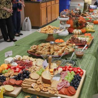 A beautifully arranged buffet table featuring a variety of snacks, fruits, and pastries.