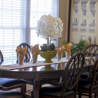 A well-decorated dining room with a table centerpiece and elegant chairs.