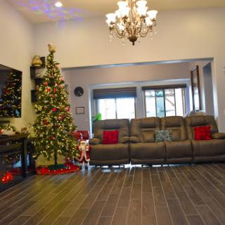A beautifully decorated living room ready for the holiday season, featuring a Christmas tree and a cozy seating area.