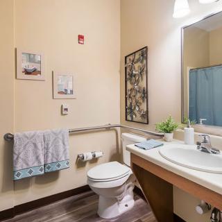 A neatly organized bathroom with a sink, mirror, and decorative elements.