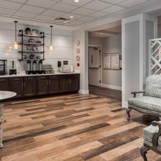 A stylish waiting room featuring a comfortable seating area and a modern coffee station.