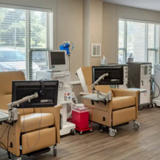 A clinic room equipped with dialysis machines and comfortable chairs for patient treatment.