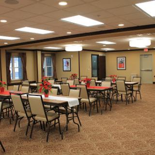 A spacious dining area set up for an event with neatly arranged tables and chairs.