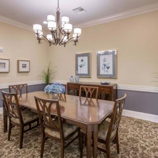 A formal dining room with a wooden table, chairs, and a chandelier.