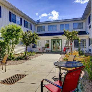 A sunny courtyard with outdoor seating and greenery.