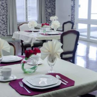 An elegantly set dining room with neatly arranged tables and chairs.