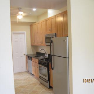 A modern kitchen with wooden cabinets and stainless steel appliances.