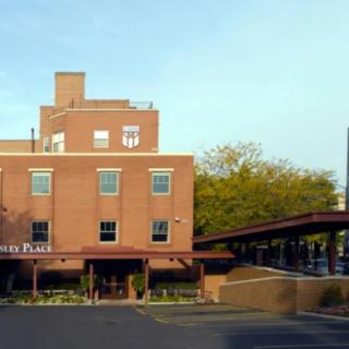 A brick building on a city street with trees in the background.